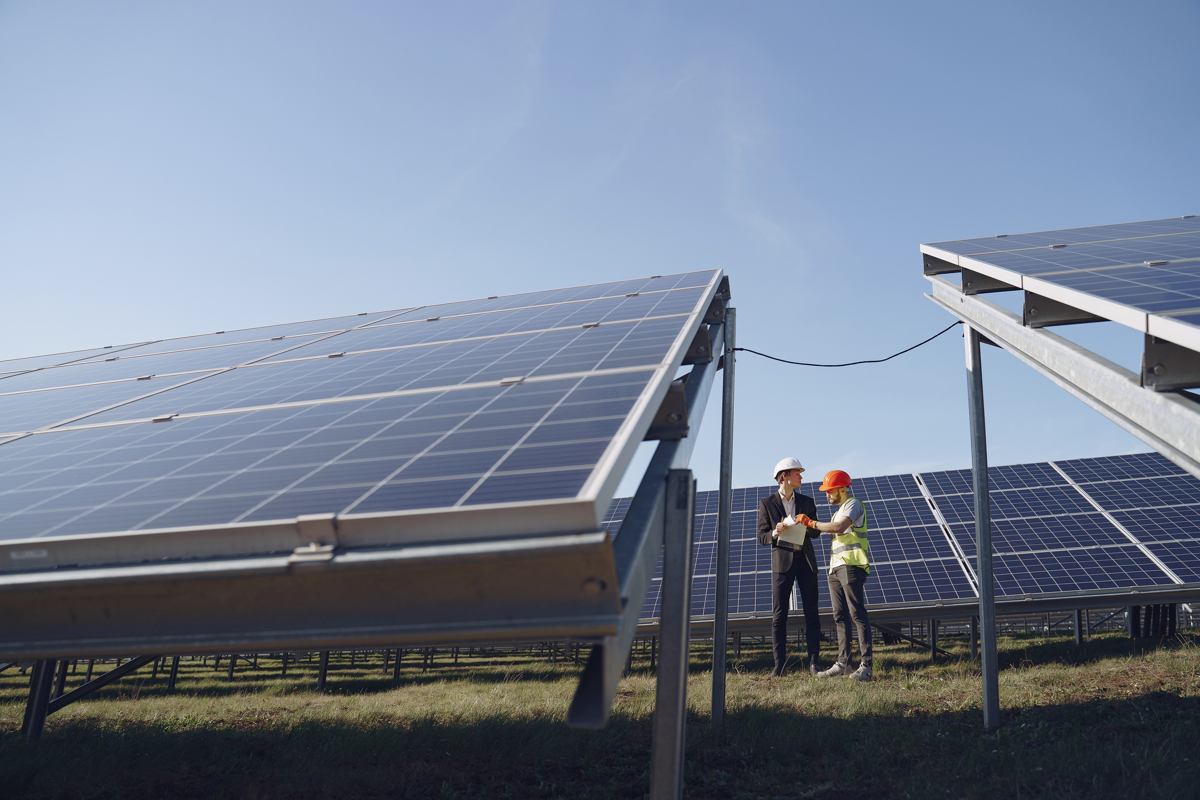 Two Electricians Standing near the Solar Panels